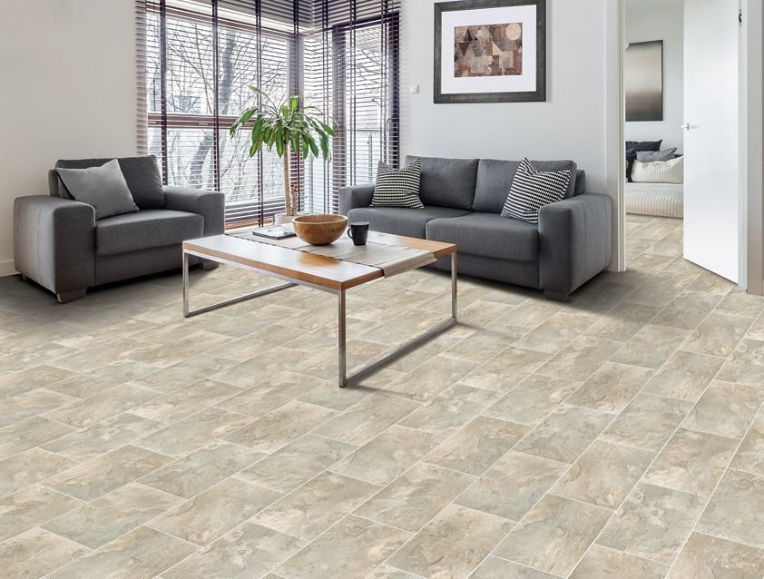 Tile flooring in a living room with grey couches.