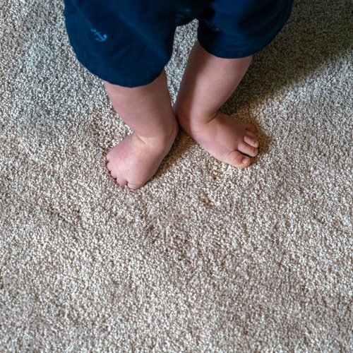 Baby standing on carpet floor in Grand Rapids, MI at Absolute Floor Covering